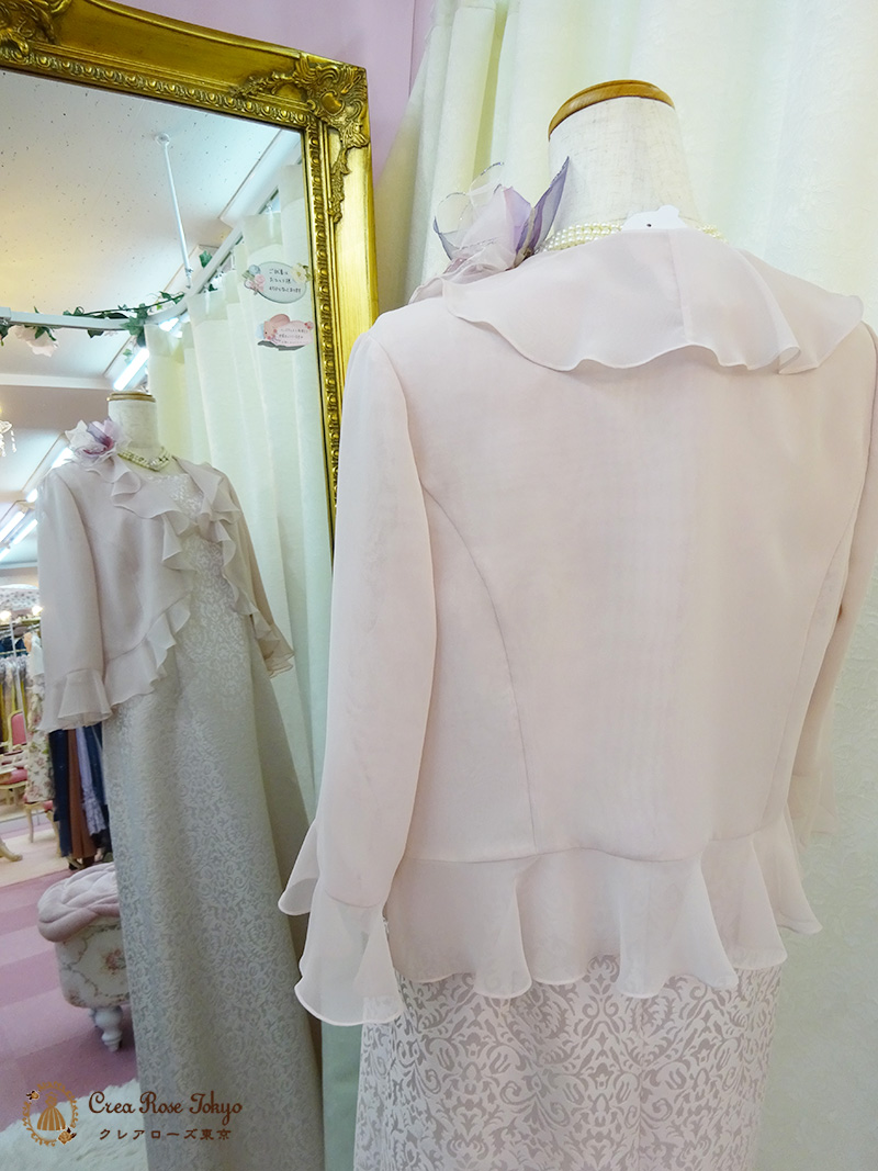 風にひるがえる薄桃色のフリルが花びらのような【クレーミーライトボレロ】