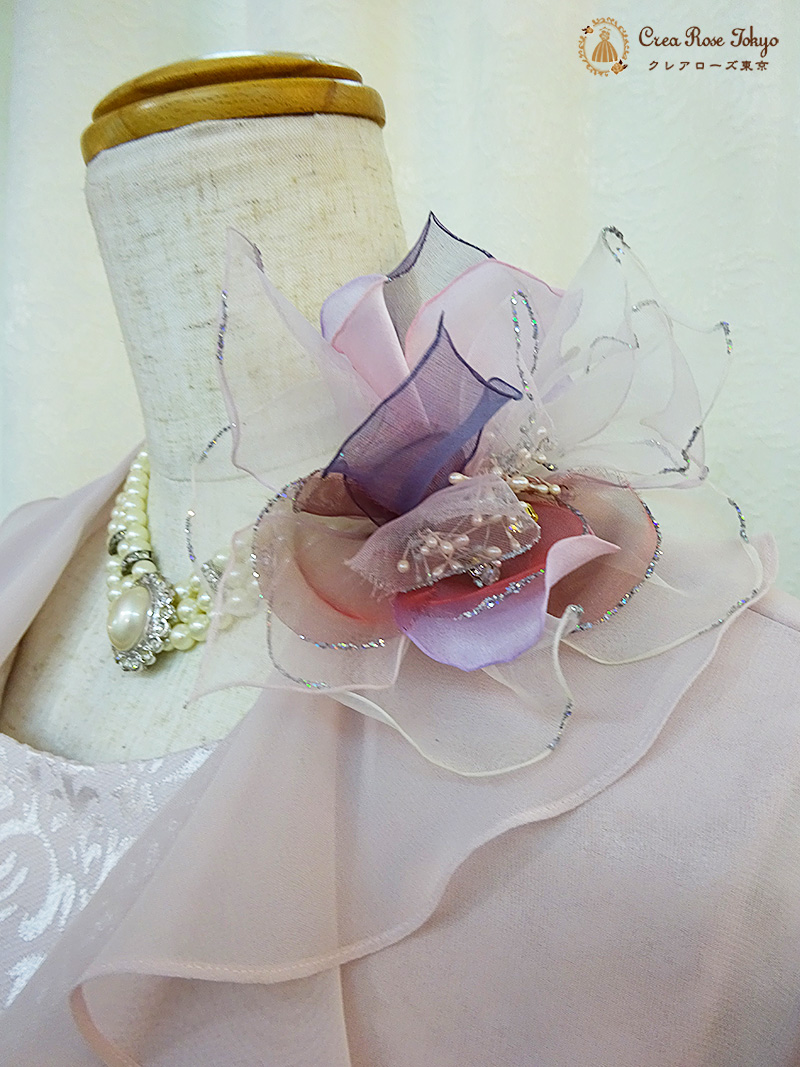 風にひるがえる薄桃色のフリルが花びらのような【クレーミーライトボレロ】